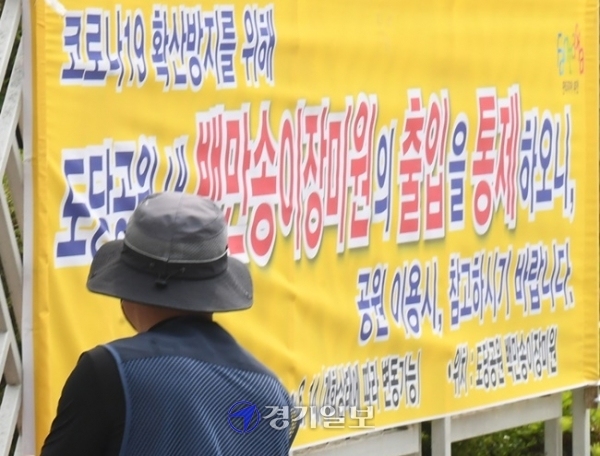 22일 오후 지역 내 코로나19 확산으로 잠정폐쇄된 부천시 백만송이장미원 앞에서 관계자가 폐쇄를 알리는 안내문을 걸고 있다. 시는 본격적인 장미 개화 시기와 맞물려 많은 시민들이 도당공원을 방문할 것을 대비해 출입 통제를 결정하고 시민들의 불편함을 최소화하기 위해 코로나19 통제와 개인위생수칙 관련 안내 방송을 실시하고 순찰과 계도를 위한 비상근무반을 운영할 계획이다. 조주현 기자
