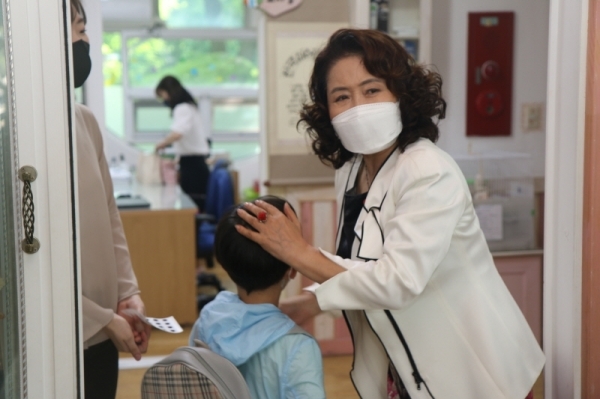 김숙희 안양시 사립유치원연합회 회장을 비롯한 은하수숲유치원 교사들이 등원하는 아이들에게 ‘붙이는 체온계’를 붙여주고 있다. 박준상기자