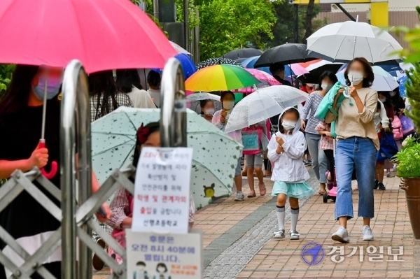 2일 오후 수원시 권선구의 한 초등학교에서 학부모들이 우산을 들고 아이들과 하교하고 있다. 경기도 곳곳에서 코로나19가 발생하는 가운데 3일부터 고1·중2·초3∼4학년들의 등교 수업이 예정돼있어 학부모들의 불안감도 커져가고 있다. 윤원규기자