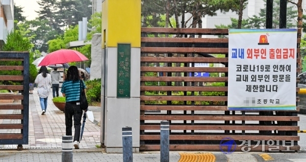 2일 오후 수원시 권선구의 한 초등학교에서 학부모들이 우산을 들고 아이들과 하교하고 있다. 경기도 곳곳에서 코로나19가 발생하는 가운데 3일부터 고1·중2·초3∼4학년들의 등교 수업이 예정돼있어 학부모들의 불안감도 커져가고 있다. 윤원규기자