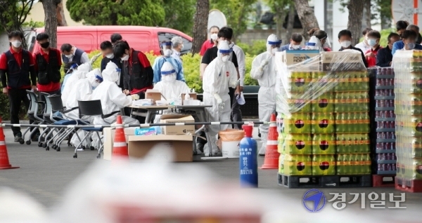 2명의 코로나19 확진자가 발생한 안양시 코카콜라 안양사업장 내 선별진료소에서 2일 오후 460여 명의 직원들이 줄지어 감염검사를 받고 있다. 김시범기자