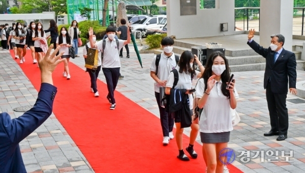 3차 등교 개학일인 3일 오전 용인시 수지구 죽전고등학교에서 1학년 학생들이 교사들의 환영속에 레드카펫을 따라 등교하고 있다. 죽전고는 이날 첫 등교하는 1학년생들을 위해 레드카펫과 텀블러 선물, 교내 음악동아리 연주회 등 다양한 이벤트를 마련했다.윤원규기자