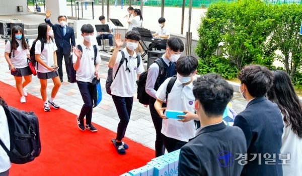 3차 등교 개학일인 3일 오전 용인시 수지구 죽전고등학교에서 1학년 학생들이 교사들의 환영속에 레드카펫을 따라 등교하고 있다. 죽전고는 이날 첫 등교하는 1학년생들을 위해 레드카펫과 텀블러 선물, 교내 음악동아리 연주회 등 다양한 이벤트를 마련했다.윤원규기자