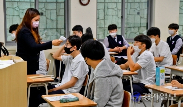 3차 등교 개학일인 3일 오전 용인시 수지구 죽전고등학교 1학년 교실에서 담임교사가 학생들의 체온을 측정하고 있다. 죽전고는 이날 첫 등교하는 1학년생들을 위해 레드카펫과 텀블러 선물, 교내 음악동아리 연주회 등 다양한 이벤트를 마련했다.윤원규기자