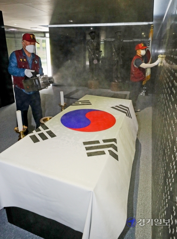 제65회 현충일을 이틀 앞둔 4일 오전 수원시 팔달구 수원현충탑에서 보건소 관계자들이 방역작업을 하고 있다. 코로나19 여파로 도내 각 지자체들은 현충일 행사를 취소하거나 최소 인원만 참여한 채 진행할 예정이다. 윤원규기자