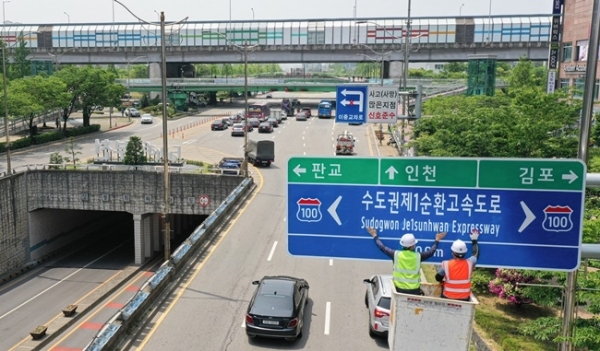 '서울외곽순환고속도로'가 '수도권제1순환고속도로'로 이름을 바꿨다. 5일 오후 부천시 일대에서 관계자들이 새 명칭이 인쇄된 도로표지판을 설치하고 있다. 경기도는 혼란을 방지하기 위해 기존 명칭과 혼용하다 교통정보시스템을 정비한 후, 오는 9월1일부터 ‘수도권 제1순환고속도로’라는 이름을 단독으로 사용할 계획이다. 조주현 기자