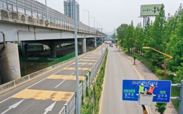 '서울외곽순환고속도로'가 '수도권제1순환고속도로'로 이름을 바꿨다. 5일 오후 부천시 일대에서 관계자들이 새 명칭이 인쇄된 도로표지판을 설치하고 있다. 경기도는 혼란을 방지하기 위해 기존 명칭과 혼용하다 교통정보시스템을 정비한 후, 오는 9월1일부터 ‘수도권 제1순환고속도로’라는 이름을 단독으로 사용할 계획이다. 조주현 기자