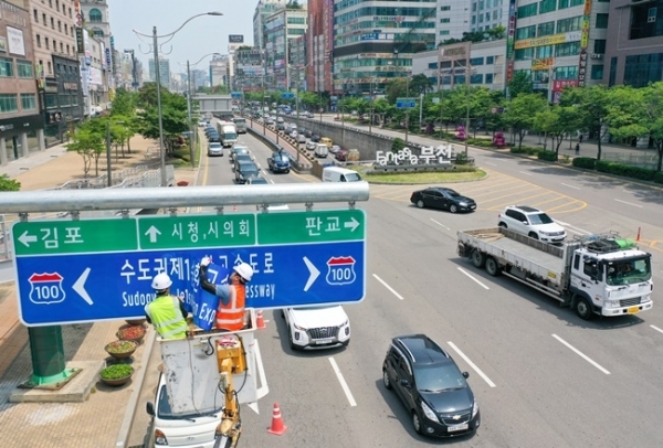 '서울외곽순환고속도로'가 '수도권제1순환고속도로'로 이름을 바꿨다. 5일 오후 부천시 일대에서 관계자들이 새 명칭이 인쇄된 도로표지판을 설치하고 있다. 경기도는 혼란을 방지하기 위해 기존 명칭과 혼용하다 교통정보시스템을 정비한 후, 오는 9월1일부터 ‘수도권 제1순환고속도로’라는 이름을 단독으로 사용할 계획이다. 조주현 기자
