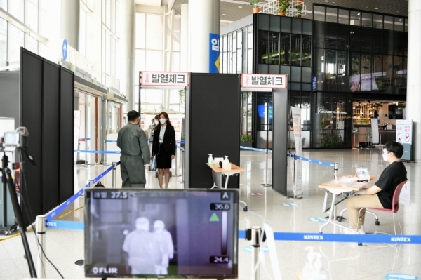 킨텍스 입구에서 방문객이 직원으로부터 발열체크를 받고 있다. 킨텍스가 코로나19 방역 시스템을 강화, 전시회를 안전하게 개최하고 있다. 킨텍스 제공