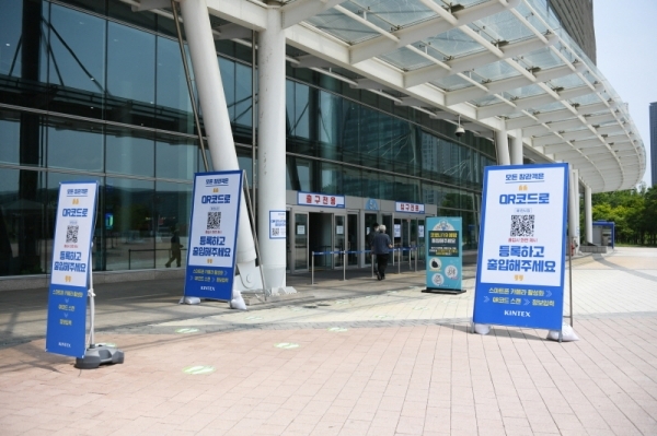 킨텍스 전시장 앞에 QR코드 출입관리시스템 이용 안내 입간판이 설치된 모습.사진=킨텍스