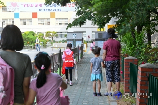 초등학교 5,6학년 등의 4차 등교가 시작된 8일 오전 군포의 한 초등학교 교문 앞에서 학부모들이 자녀를 배웅하고 있다. 경기도 등 수도권지역에서 코로나19의 산발적 감염이 계속되면서 자녀를 학교로 보내는 학부모들의 근심이 커지고 있다. 윤원규기자
