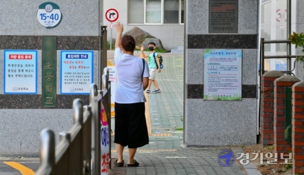 초등학교 5,6학년 등의 4차 등교가 시작된 8일 오전 군포의 한 초등학교 교문 앞에서 학부모들이 자녀를 배웅하고 있다. 경기도 등 수도권지역에서 코로나19의 산발적 감염이 계속되면서 자녀를 학교로 보내는 학부모들의 근심이 커지고 있다. 윤원규기자