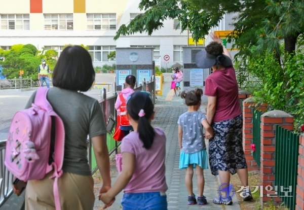 초등학교 5,6학년 등의 4차 등교가 시작된 8일 오전 군포의 한 초등학교 교문 앞에서 학부모들이 자녀를 배웅하고 있다. 경기도 등 수도권지역에서 코로나19의 산발적 감염이 계속되면서 자녀를 학교로 보내는 학부모들의 근심이 커지고 있다. 윤원규기자