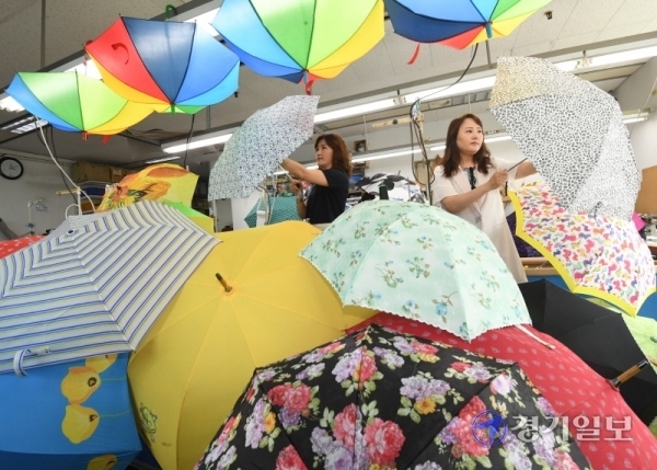 8일 오후 경기도내 한 양산 제조업체에서 직원들이 다양한 색상으로 제작된 양산을 검수하고 있다. 코로나19 확산 우려로 경로당과 복지관 등에 설치된 무더위쉼터가 임시 휴관되면서 경기지역 등 전국 지자체들이 폭염 피해 예방 대책으로 ‘양산 쓰기’ 운동을 벌이고 있다.  조주현기자