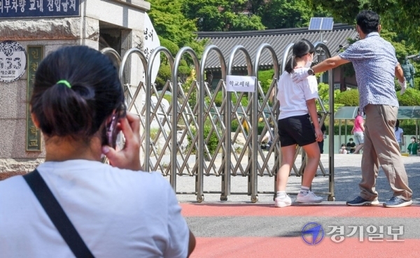9일 오전 코로나19 확진자가 나온 인천시 미추홀구의 한 초등학교 앞에서 학부모가 검체 검사를 받으러 가는 자녀를 보며 걱정스러운 듯 통화를 하고 있다. 장용준기자