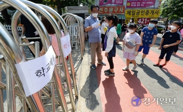 9일 오전 코로나19 확진자가 나온 인천시 미추홀구의 한 초등학교 교문 앞에서 검체 검사를 받기 위해 나온 학생들이 발열검사를 받고 있다. 장용준기자