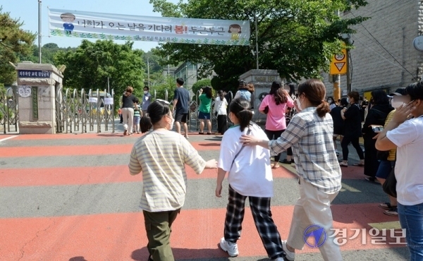 9일 오전 코로나19 확진자가 나온 인천시 미추홀구의 한 초등학교 앞에서 학부모들이  검체 검사를 받기 위해 학생들을 데리고 교문으로 들어서고 있다. 장용준기자