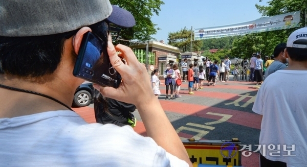9일 오전 코로나19 확진자가 나온 인천시 미추홀구의 한 초등학교 앞에서 학부모가 검체 검사를 받으러 가는 자녀를 보며 걱정스러운 듯 통화를 하고 있다. 장용준기자