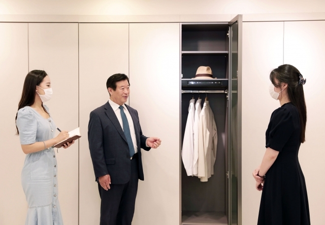 ▲ [사진1] 에몬스가구 김경수 회장이 직접 대리점 판매 책임자에게 의류관리기 스타일존S을 설명하고 있다