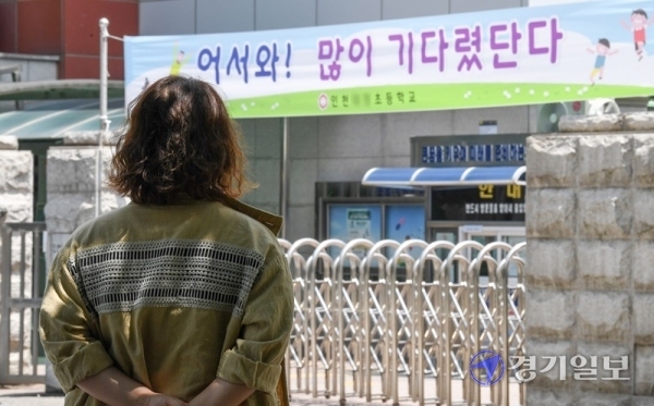 11일 인천시 부평·계양구 관내 유·초·중·고 및 특수학교 등 243곳에 대해 등교수업을 재개한 가운데 부평구의 한 초등학교 정문에서 학부모가 하교하는 자녀를 기다리고 있다. 인천시교육청은 지난 2일 경기도 부천 물류센터발 코로나19 집단감염 확산에 따라 부평구와 계양구 관내 243곳에 대해  고3을 제외하고 원격수업으로 전환했다. 장용준기자