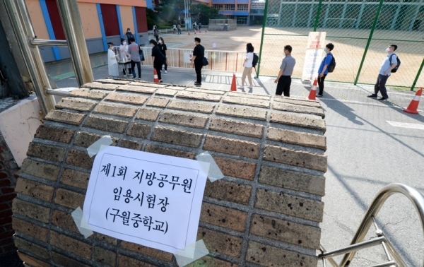 인천을 비롯한 전국에서 2020년 제1회 8·9급 지방직 공무원 공채 시험이 치러진 13일 오전 남동구 구월중학교 시험장에서 수험생들이 거리두기를 하며  1차 발열검사와 함께 손 소독을 하고 있다. 장용준기자