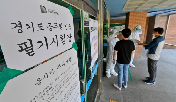 '2020년도 경기도 8·9급 지방직 공무원 공채 필기시험'이 열린 13일 오전 수원시의 한 시험장에서 수험생들이 입장 전 체온 측정과 손 소독을 하고 있다. 올해 경기도 8·9급 전체 4,978명 선발 예정에 4만2261명이 응시하면서 8.5의 경쟁률을 보였다. 윤원규기자