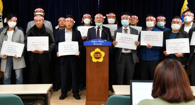 ▲ 경기도상인연합회 이충환 회장과 시장상인 등 참석자들이 7일 경기도의회 브리핑룸에서 농협 하나로마트 재난기본소득 지역화폐 사용을 반대하는 기자회견을 하고 있다.경기일보 DB