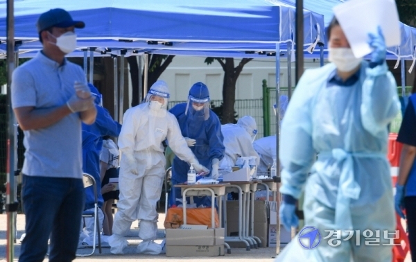 14일 코로나19 확진자가 발생한 인천시 계양구 효성초등학교에 설치된 선별진료소에서 레벨D 방호복을 입은 의료진들이 불볕더위속에 분주히 검체 채취를 하고 있다. 장용준기자