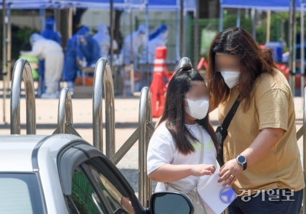 14일 코로나19 확진자가 발생한 인천시 계양구 효성초등학교에 설치된 선별진료소에서 검체 검사를 받은 한 학생의 보호자가 안내문을 읽고 있다. 장용준기자