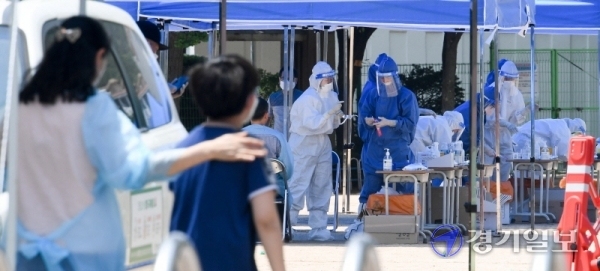 14일 코로나19 확진자가 발생한 인천시 계양구 효성초등학교에 설치된 선별진료소에서 레벨D 방호복을 입은 의료진들이 불볕더위속에 분주히 검체 채취를 하고 있다. 장용준기자