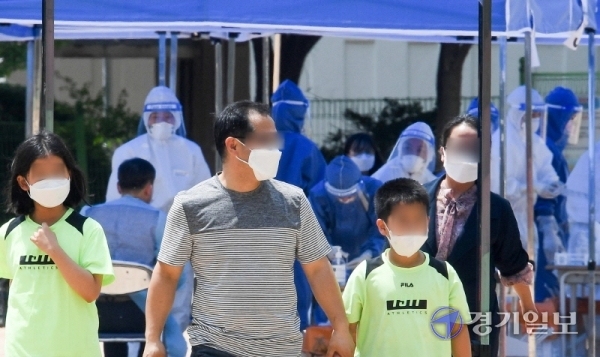 14일 코로나19 확진자가 발생한 인천시 계양구 효성초등학교에 설치된 선별진료소에서 검체 검사를 받은 학생들과 보호자가 교문을 나서고 있다. 장용준기자