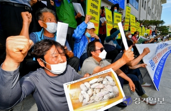 친환경 학교급식 경기도운동본부, 농업인연합회 등 관계자들이 15일 오후 경기도의회 앞에서 ‘경기도가정꾸러미 파행 실태 규탄 및 학교급식 계약재배 농가 피해 대책’을 촉구하는 기자회견을 하고 있다. 윤원규기자