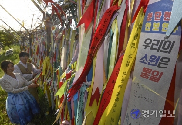 얼어붙은 남북관계 속에 맞이한 6·15 남북공동선언 20주년인 15일 오후 파주 임진각에서 시민들이 남북 평화통일을 기원하는 리본을 철책에 달고 있다. 조주현기자
