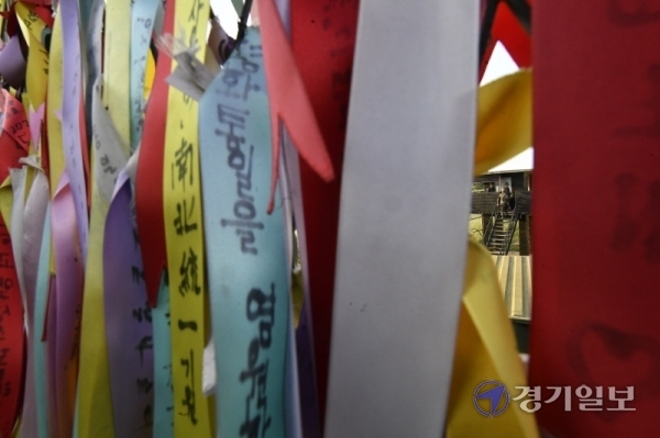 얼어붙은 남북관계 속에 맞이한 6·15 남북공동선언 20주년인 15일 오후 파주 임진각에서 시민들이 남북 평화통일을 기원하는 리본을 철책에 달고 있다. 조주현기자