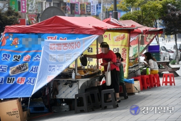 16일 오후 안산시내 한 거리 포장마차에서 시민들이 음식을 사먹고 있다. 경기지역 노점상의 상당수가 방역에 취약하거나 현금영업을 선호하면서 코로나19 확산의 사각지대가 될 수 있다는 지적이 일고 있다. 김시범기자
