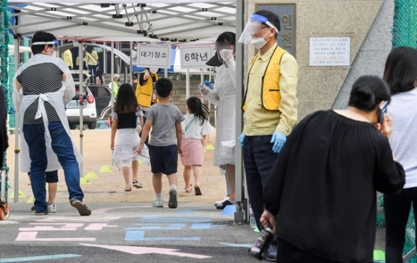 17일 오전 코로나19 확진자가 나온 인천시 미추홀구의 한 초등학교 학생들이 검체 검사를 받기 위해 운동장으로 들어가고 있다. 장용준기자