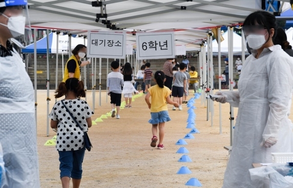 17일 오전 코로나19 확진자가 나온 인천시 미추홀구의 한 초등학교 학생들이 검체 검사를 받기 위해 운동장으로 들어가고 있다. 장용준기자
