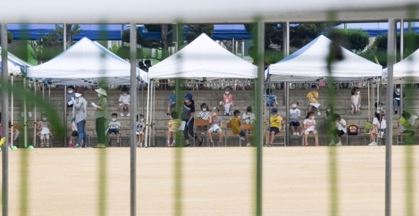 17일 오전 코로나19 확진자가 나온 인천시 미추홀구의 한 초등학교 운동장에서 검체 검사를 받는 학생들이 거리를 두고 앉아 있다. 장용준기자