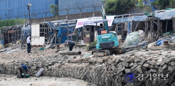 17일 오전 인천시 동구 만석부두에서 동구청 관계자들이 폐허로 남은 굴막(굴 까는 작업장)을 철거하고 있다. 굴막은 6.25 전쟁이후 만석부두에 자리잡은 실향민들이 제철생굴을 까며 생계를 이어왔던 곳이다. 장용준기자