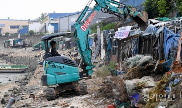 17일 오전 인천시 동구 만석부두에서 동구청 관계자들이 폐허로 남은 굴막(굴 까는 작업장)을 철거하고 있다. 굴막은 6.25 전쟁이후 만석부두에 자리잡은 실향민들이 제철생굴을 까며 생계를 이어왔던 곳이다. 장용준기자