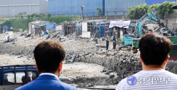 17일 오전 인천시 동구 만석부두에서 동구청 관계자들이 폐허로 남은 굴막(굴 까는 작업장)을 철거하고 있다. 굴막은 6.25 전쟁이후 만석부두에 자리잡은 실향민들이 제철생굴을 까며 생계를 이어왔던 곳이다. 장용준기자