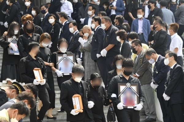 '이천 한익스프레스 물류창고 화재 사고 희생자 합동 영결식'이 열린 20일 오전 이천시 서희청소년문화센터에서 유가족들이 고인의 위패와 영정을 들고 영결식장을 나서고 있다. 조주현 기자