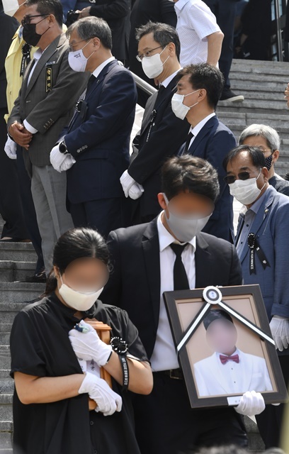 '이천 한익스프레스 물류창고 화재 사고 희생자 합동 영결식'이 열린 20일 오전 이천시 서희청소년문화센터에서 유가족들이 고인의 위패와 영정을 들고 영결식장을 나서고 있다. 조주현 기자