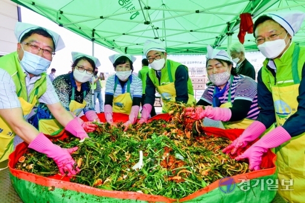 22일 오전 북시흥농협농산물창고에서 열린 '찬찬찬(찬饌贊) 사랑의 여름김치 나눔행사'에서 김장섭 농협경기지역본부장이 농협관계자들과 열무김치를 담그고 있다. 이번 행사는 농촌의 독거노인과 불우이웃을 돕기위해 경기농협과 농가 주부모임 경기도연합회가 함께 했다. 윤원규기자