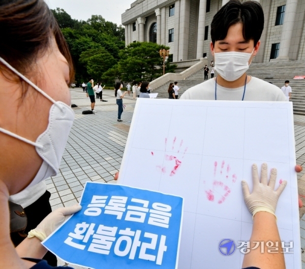 23일 오후 경희대학교 국제캠퍼스에서 열린 '경희대학교 학생의 권리를 되찾기 위한 경희인 집중공동행동'에 참가한 학생들이 코로나19 사태로 변화된 수업환경과 관련해 등록금 반환, '선택적 P/F제도'(선택적 패스제, 교강사의 성적평가 이후 성적정정기간에 부여받은 학점에 대해 학생이 선택) 도입 등을 촉구하며 손도장 퍼포먼스를 하고 있다. 윤원규기자