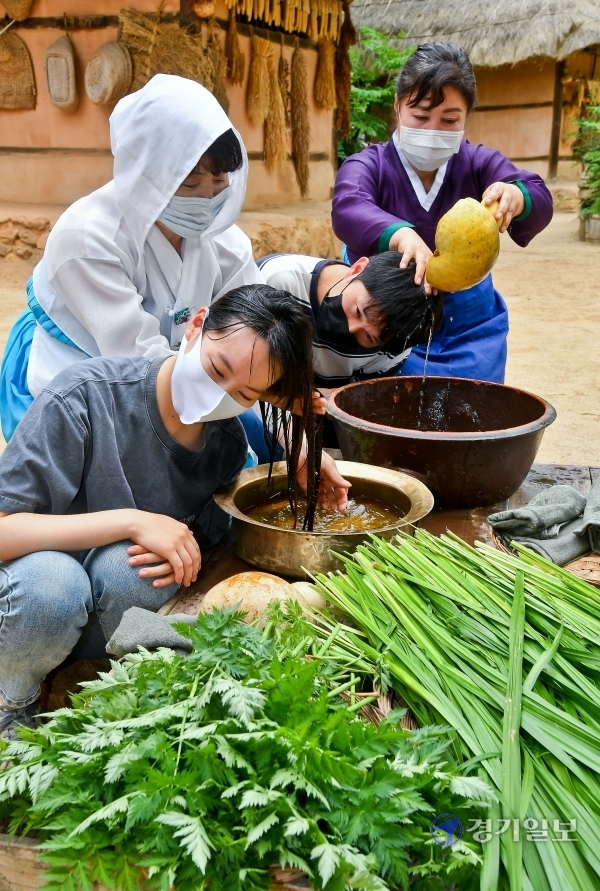 창포물에 머리감기 단오를 이틀 앞둔 23일 오후 용인 한국민속촌에서 관계자들이 창포물에 머리 감기 시연을 하고 있다. 창포물에 머리를 감으면 귀신을 몰아내고, 머리카락이 건강해 진다는 속설이 전해진다.  윤원규기자