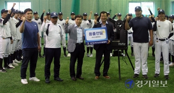 ▲ 경기도야구소프트볼협회 김재철 회장(왼쪽 네 번째) 협회장이 수원 유신고 야구부에 자동 피칭머신을 전달하고 있다.김경수기자