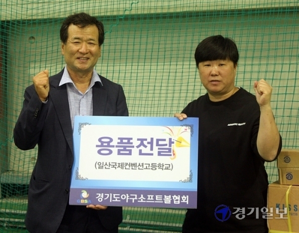 ▲ 경기도야구소프트볼협회 김재철(왼쪽) 회장이 허미진 일산국제컨벤션고 소프트볼팀 감독에게 용품을 전달한 뒤 기념촬영을 하고 있다.김경수기자