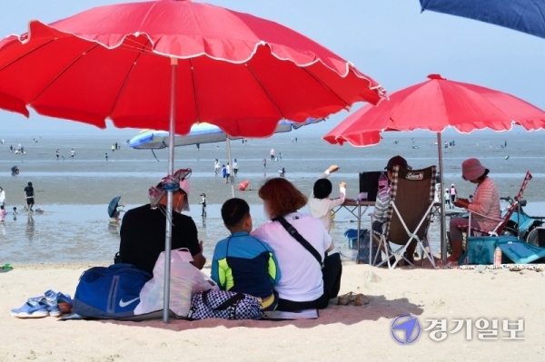 인천지역 7개 해수욕장이 정식 개장 후 첫 주말을 맞은 5일 중구 무위도 하나개 해수욕장에서 시민들이 거리두기로 설치한 그늘막 아래에서 더위를 식히고 있다. 장용준기자