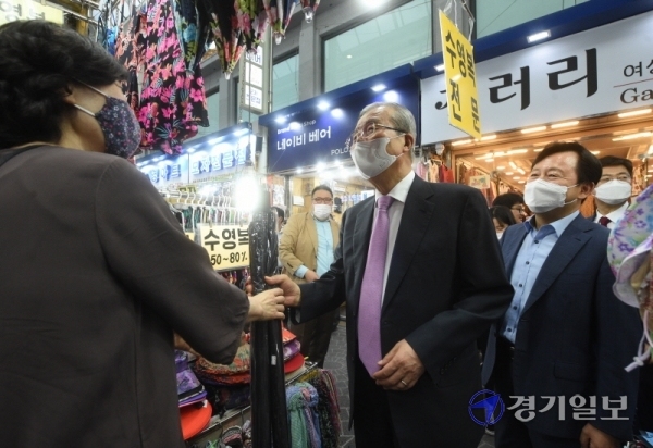 김종인 미래통합당 비상대책위원장이 6일 오후 수원 영동시장을 찾아 우산을 구매하고 있다.  김 위원장은 시장 상인들과의 간담회에서 코로나19 사태와 관련, 정부의 중장기적 대책을 요구했다. 윤원규기자